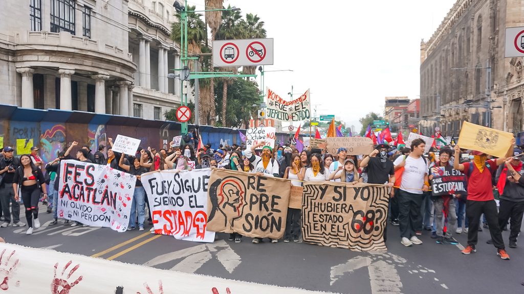 Foto: Gabriel Morales | Participantes hacen una parada junto al Palacio de Bellas Artes y muestran sus pancartas durante la marcha conmemorativa del 2 de octubre de 2026.